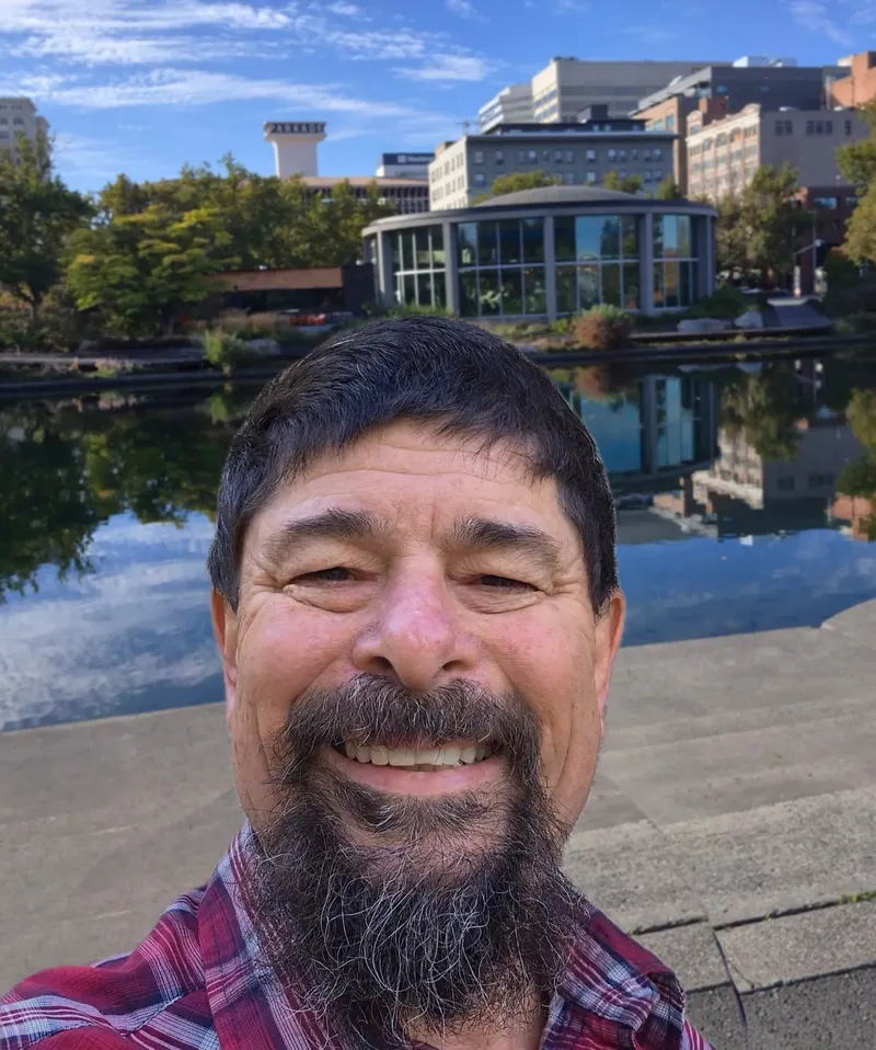 Alec Gonzales smiling, with downtown Spokane behind him
